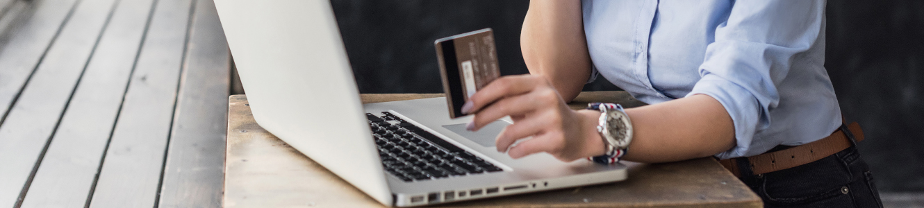 Woman using debit/credit card at laptop